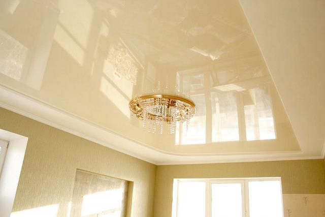 бежевый глянцевый потолок с люстрой